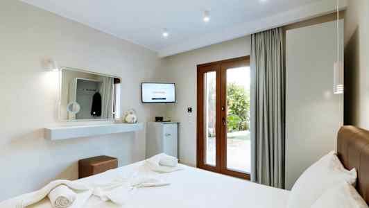 Moderne hotellrom med en dobbeltseng og utsikt mot hagen. (AI-generert tekst)