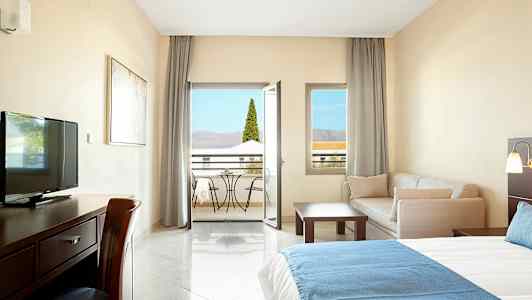 Hotellrom med møbler og balkong. (AI-generert tekst)