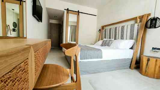 Moderne hotellrominteriør med dobbeltseng og treinteriør. (AI-generert tekst)