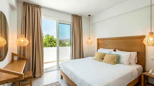 Rom med en dobbeltseng, en skrivebordskrok og et vindu som fører til en balkong. (AI-generert tekst)