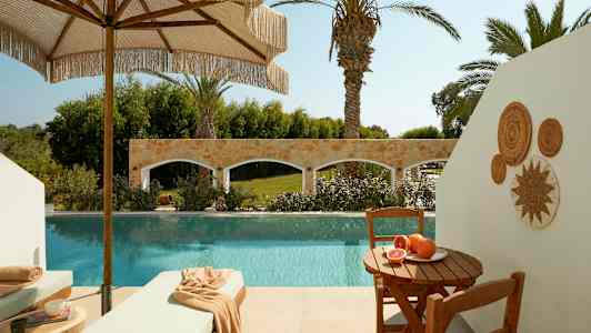 Terrasse med basseng, solsenger og et bord med fersk frukt. (AI-generert tekst)