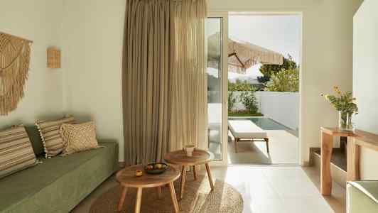 Moderne rom med grønn sofa, tremøbler og en glassdør som fører til en uteplass med basseng. (AI-generert tekst)