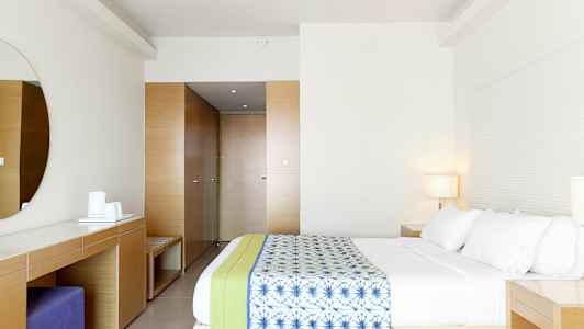 Et moderne hotellrom med en romslig seng og minimalistisk innredning. (AI-generert tekst)