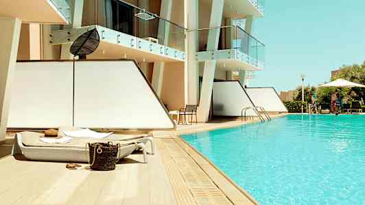 Utendørsbasseng med solsenger ved et moderne hotell. (AI-generert tekst)