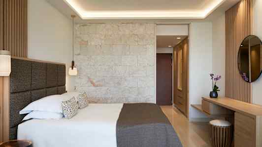 Et moderne hotellrom med en dobbeltseng og treinteriør. (AI-generert tekst)