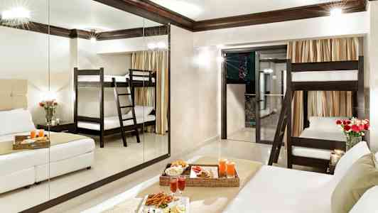 Hotellrom med en køyeseng, dobbeltseng og servert måltid. (AI-generert tekst)