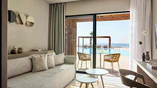 Lyse stue møbler med utsikt over basseng og sjø. (AI-generert tekst)