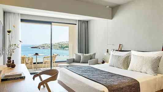 Hotellrom med moderne interiør og utsikt over havet. (AI-generert tekst)