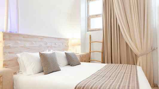 Et lyst soverom med en stor seng, puter og en detaljert treinredning. (AI-generert tekst)