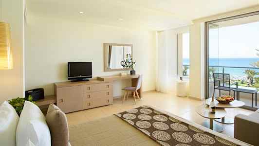 Lyst hotellrom med havutsikt og balkong. (AI-generert tekst)