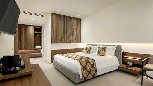 Hotellrom med moderne design, inkludert en stor seng og tretrekk. (AI-generert tekst)