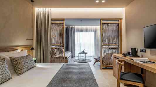 Et moderne hotellrom med en stor seng, et skrivebord og en sitteområde. (AI-generert tekst)