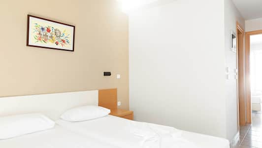 Et hotellrom med to senger, et nattbord og et maleri på veggen. (AI-generert tekst)