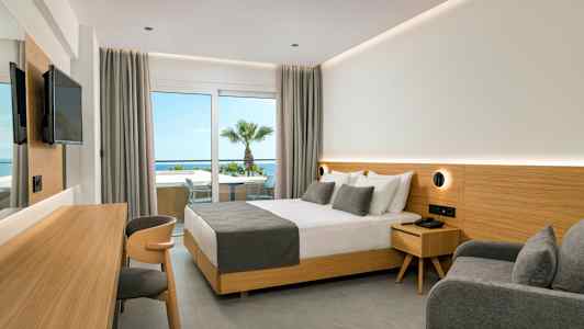 Hotellrom med dobbeltseng, grå innredning og utsikt mot havet. (AI-generert tekst)