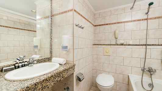 Bilde av et baderom med servant, speil, toalett og badekar. (AI-generert tekst)