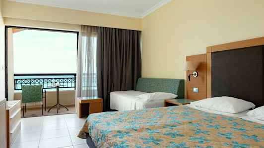 Hotellrom med senger og balkong. (AI-generert tekst)