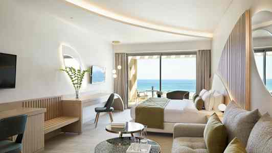 Et hotellrom med moderne innredning og utsikt mot havet. (AI-generert tekst)