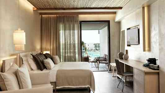 Hotellrom med dobbeltseng og utsikt over bassengområdet. (AI-generert tekst)