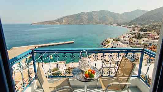 Balkong med utsikt over en bukt og en småby ved sjøen. (AI-generert tekst)