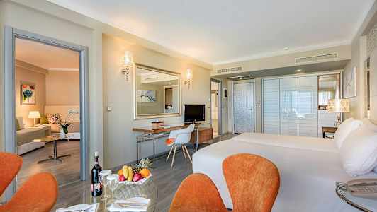 Hotellrom med dobbeltseng, sittegruppe og skrivebord. (AI-generert tekst)