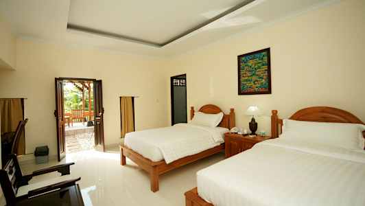 Hotellrom med to senger og en glassdør som fører til en uteplass. (AI-generert tekst)