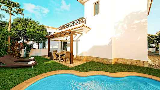 Bilde av en villa med et lite svømmebasseng, plen og utemøbler på en romslig terrasse. (AI-generert tekst)