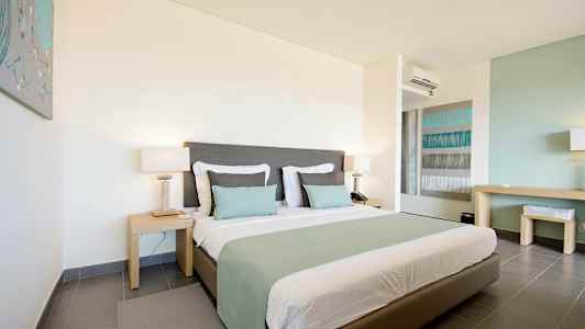 Et hotellrom med en stor seng, to nattbord og moderne interiør. (AI-generert tekst)