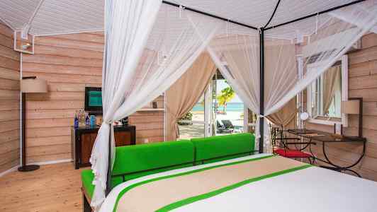 Lyst soverom med himmelseng og utsikt mot stranden. (AI-generert tekst)