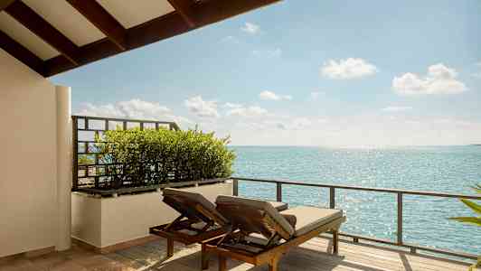 To solsenger på en terrasse med utsikt over havet. (AI-generert tekst)