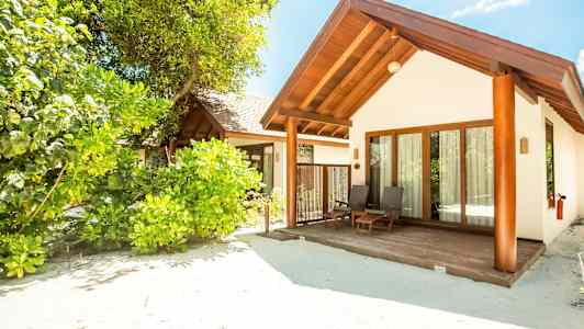 En strandvilla omgitt av frodig vegetasjon. (AI-generert tekst)