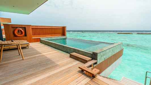 Bilde av en terrasse med et privat basseng, havet synlig i bakgrunnen. (AI-generert tekst)