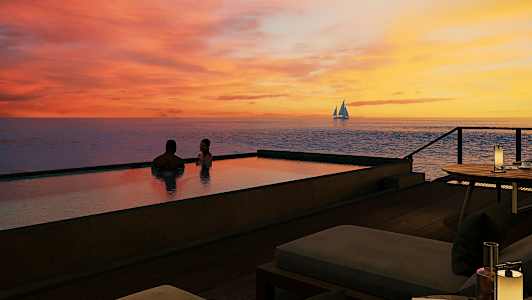 To personer sitter i et infinitybasseng ved solnedgang med en seilbåt på havet i bakgrunnen. (AI-generert tekst)