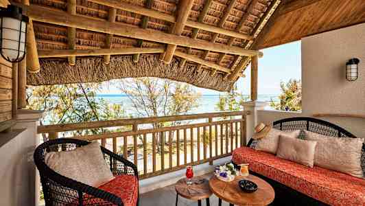 Terrasse med sittemøbler, bord og utsikt over havet. (AI-generert tekst)