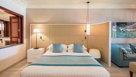 Et moderne soverom med en stor seng, blå pynteputer og matchende sengetøy. (AI-generert tekst)