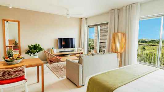 Moderne innredet leilighet med stue, spiseplass, TV og utsikt over grøntområder. (AI-generert tekst)