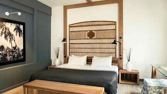 Et hotellrom med en dobbeltseng, tremøbler og moderne interiør. (AI-generert tekst)