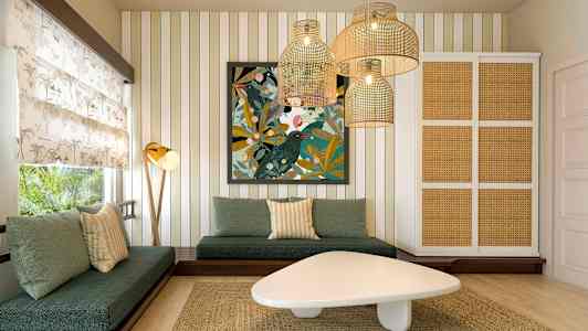 En stue med grønne sofaer, et kunstverk på veggen og hengende lamper i rottingstil. (AI-generert tekst)