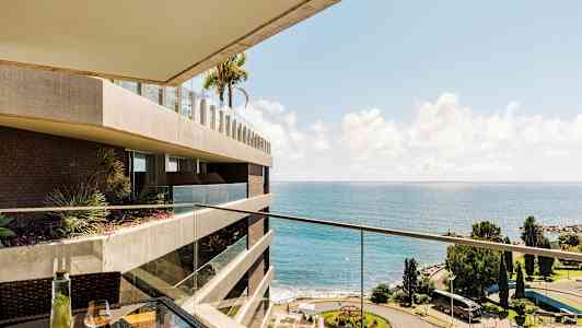 Utsikt fra balkong med hav og park. (AI-generert tekst)