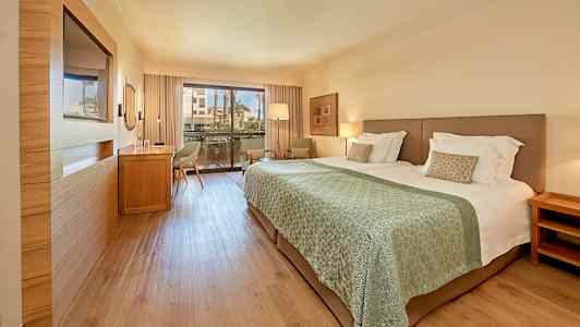 Hotellrom med dobbeltseng og balkong. (AI-generert tekst)