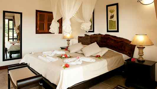 Hotellrom med dobbeltseng, dekorert med blomster og håndklær. (AI-generert tekst)