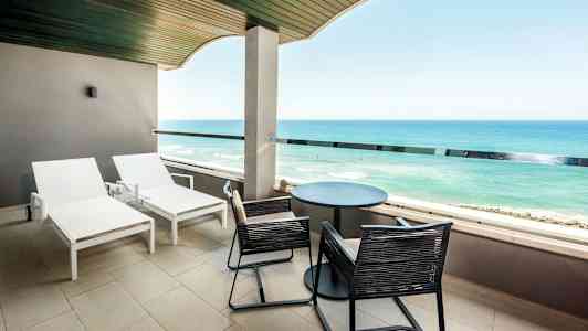 Balkong med solsenger og utsikt over havet. (AI-generert tekst)