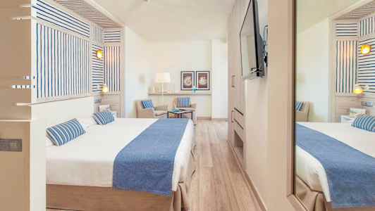 Hotellrom med dobbeltseng og stol, innredet i en lys og moderne stil. (AI-generert tekst)