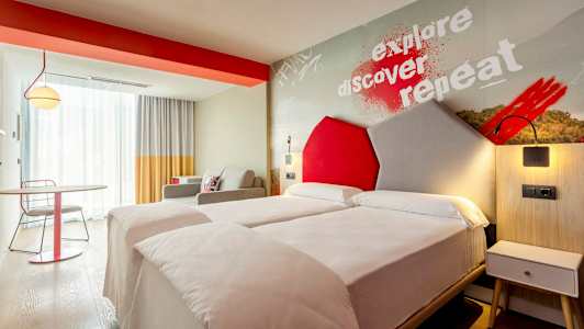 Et moderne hotellrom med to enkeltsenger og fargerike detaljer. (AI-generert tekst)