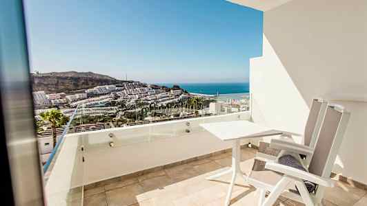 En balkong med utsikt over sjøen og bygninger. (AI-generert tekst)