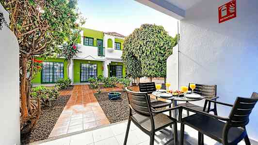 Utendørsområde med sitteplasser og frodig omgivelser. (AI-generert tekst)