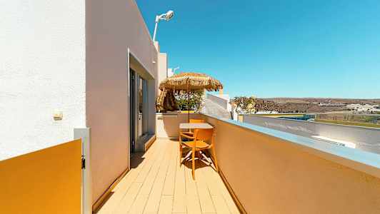 Balkongen med bord, stoler og parasoll med utsikt over omgivelsene. (AI-generert tekst)