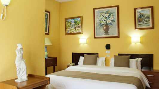 Et hotellrom med en dobbeltseng, dekorative vegger med malerier og en liten statue på en møbel. (AI-generert tekst)