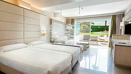 Hotellrom med to senger og åpning mot hagen. (AI-generert tekst)