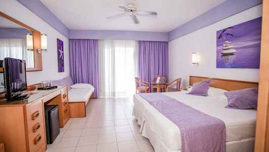 Hotellrom med en stor seng, en enkeltseng, et bord med stoler og en TV-benk. (AI-generert tekst)