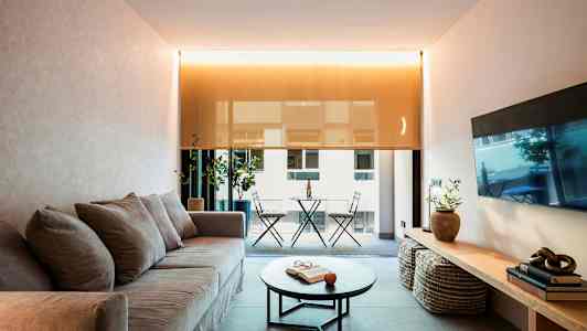 Stue med sofa, salongbord og utsikt til balkong. (AI-generert tekst)